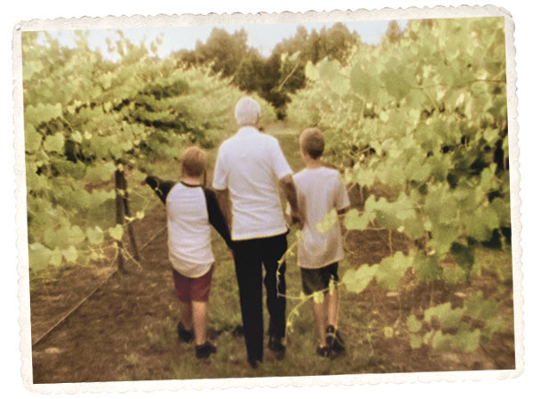 Jonathan and Dave Fussell Jr walk through the vineyards with their grandfather, Big D.